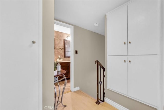 hallway featuring light wood-style floors and baseboards