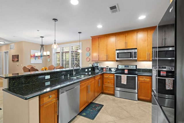 kitchen featuring visible vents, stainless steel appliances, a peninsula, and a sink