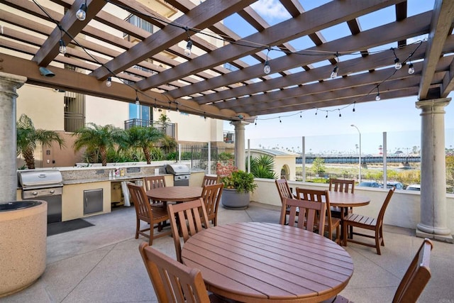 view of patio / terrace with exterior kitchen, area for grilling, a pergola, and outdoor dining area