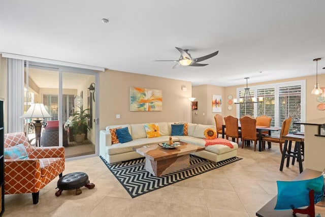 living room with tile patterned floors and ceiling fan with notable chandelier