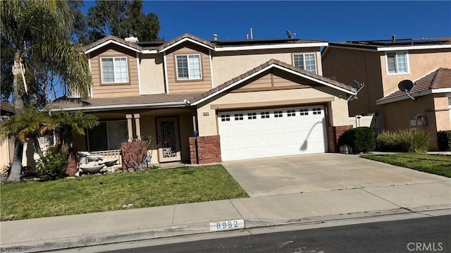 8982 Dahlia Dr, Corona, CA 92883 - view of front of house featuring stucco siding, driveway, a front lawn, solar panels, and a garage