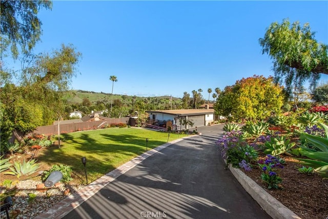 exterior space featuring a front lawn, fence, and a garage