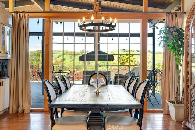 sunroom with beam ceiling and an inviting chandelier
