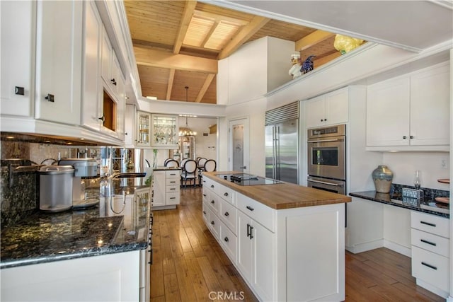 kitchen with wooden counters, white cabinetry, a kitchen island, and appliances with stainless steel finishes