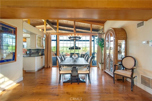 dining space with visible vents, hardwood / wood-style flooring, and an inviting chandelier