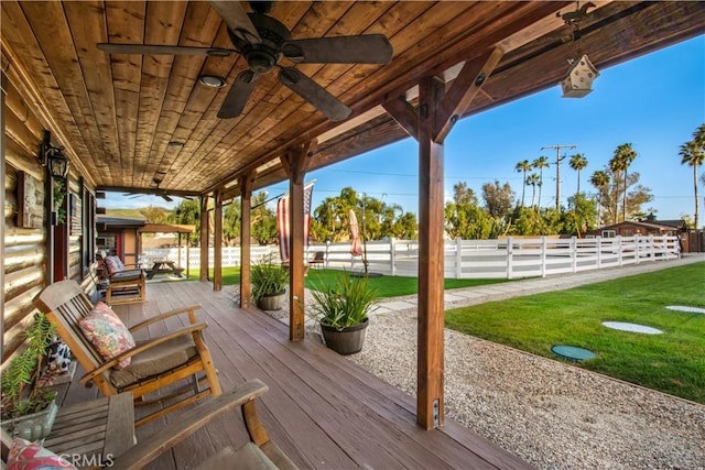 wooden deck featuring a ceiling fan, fence, and a lawn