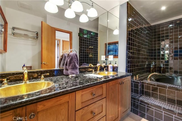 bathroom with a relaxing tiled tub, double vanity, and a sink