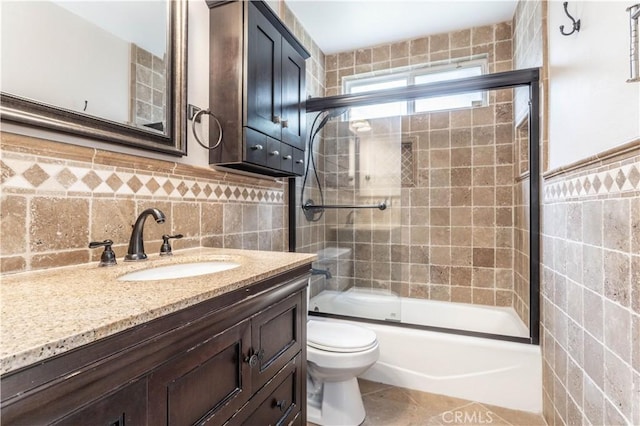 18715 Plummer St, Northridge, CA 91324 - full bath with tile walls, enclosed tub / shower combo, toilet, vanity, and tile patterned flooring