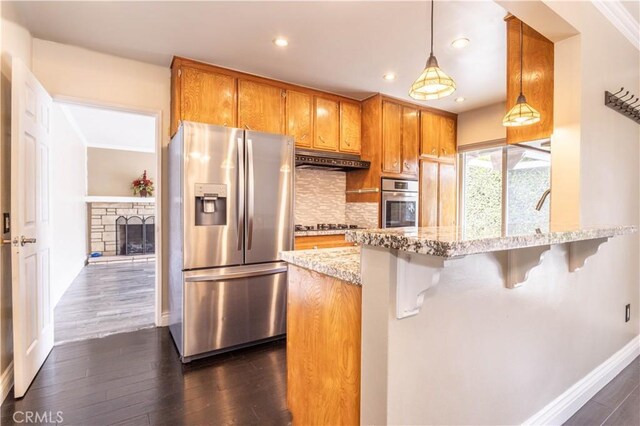 18715 Plummer St, Northridge, CA 91324 - kitchen featuring appliances with stainless steel finishes, under cabinet range hood, brown cabinets, dark wood-style flooring, and recessed lighting