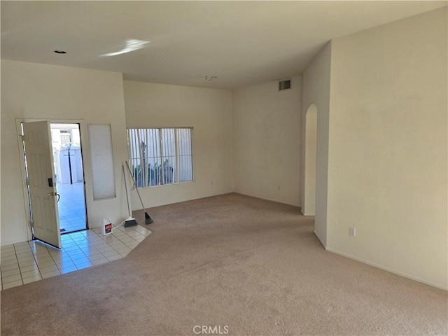 37467 Golden Pebble Ave, Palm Desert, CA 92211 - tiled spare room featuring carpet floors, arched walkways, and visible vents