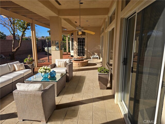 view of patio / terrace featuring an outdoor living space with a fire pit, a ceiling fan, and fence