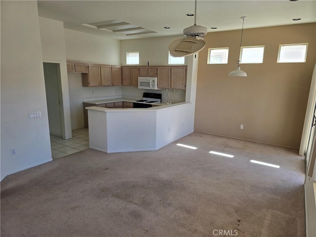 37467 Golden Pebble Ave, Palm Desert, CA 92211 - kitchen featuring light countertops, a peninsula, white appliances, a towering ceiling, and light colored carpet