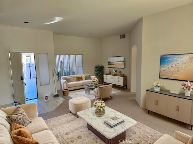 37467 Golden Pebble Ave, Palm Desert, CA 92211 - living area featuring arched walkways, light carpet, and visible vents