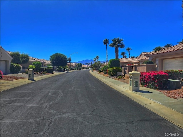 37467 Golden Pebble Ave, Palm Desert, CA 92211 - view of street featuring sidewalks, street lights, a mountain view, and curbs