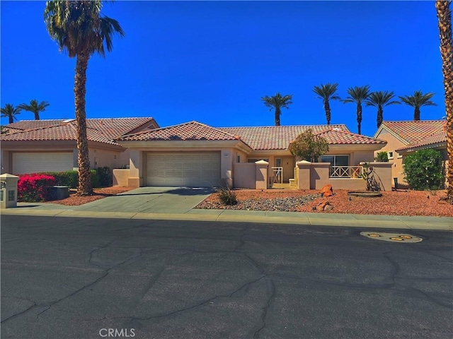 37467 Golden Pebble Ave, Palm Desert, CA 92211 - mediterranean / spanish house featuring stucco siding, a tiled roof, and a garage
