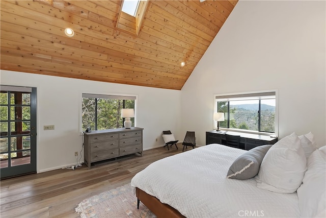 bedroom with wood finished floors, baseboards, high vaulted ceiling, a skylight, and wooden ceiling
