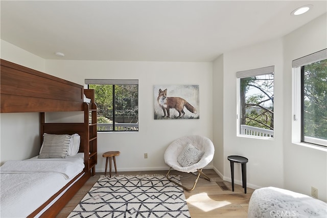 bedroom with recessed lighting, wood finished floors, and baseboards