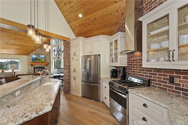 kitchen featuring a sink, stainless steel appliances, wooden ceiling, wall chimney exhaust hood, and open floor plan