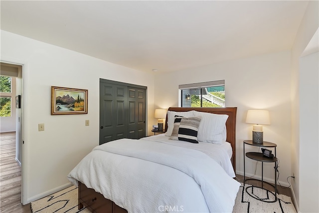 bedroom featuring a closet, baseboards, and light wood-style floors