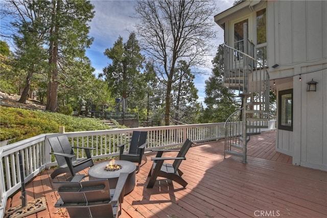 wooden terrace with stairs and an outdoor fire pit