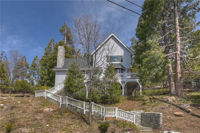 view of front of property with stairway and a chimney