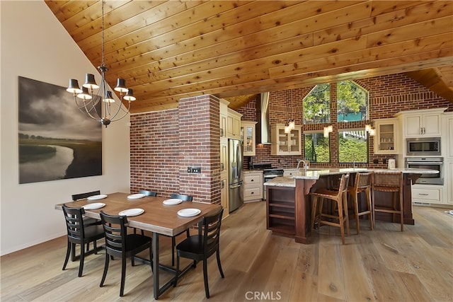 dining area featuring an inviting chandelier, light wood-style flooring, wood ceiling, and brick wall