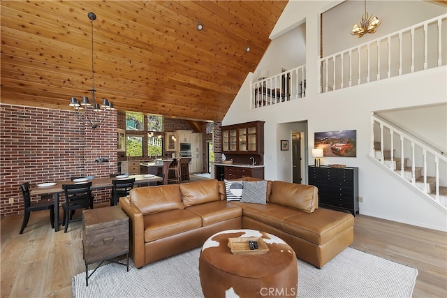 living area with a chandelier, stairs, wooden ceiling, a towering ceiling, and wood finished floors