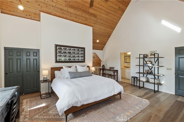 bedroom featuring wooden ceiling, high vaulted ceiling, ensuite bathroom, and wood finished floors