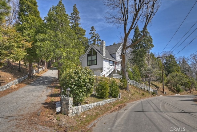 view of property exterior with stairs and a chimney