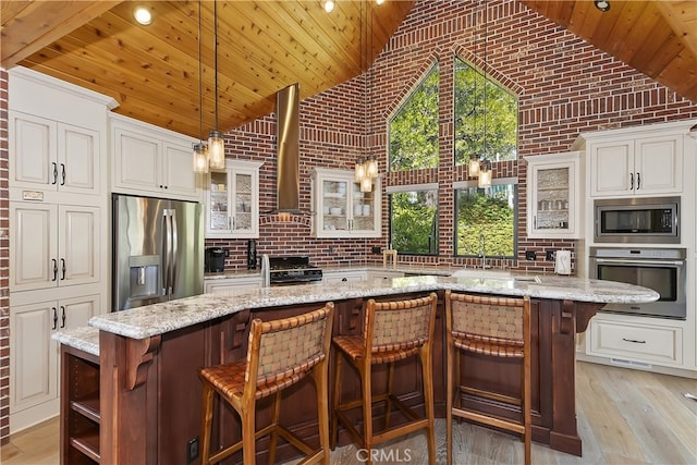 kitchen with wood ceiling, stainless steel appliances, light wood-style floors, high vaulted ceiling, and wall chimney exhaust hood