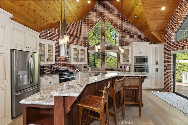 kitchen with appliances with stainless steel finishes, wood ceiling, wall chimney exhaust hood, and light wood-style floors