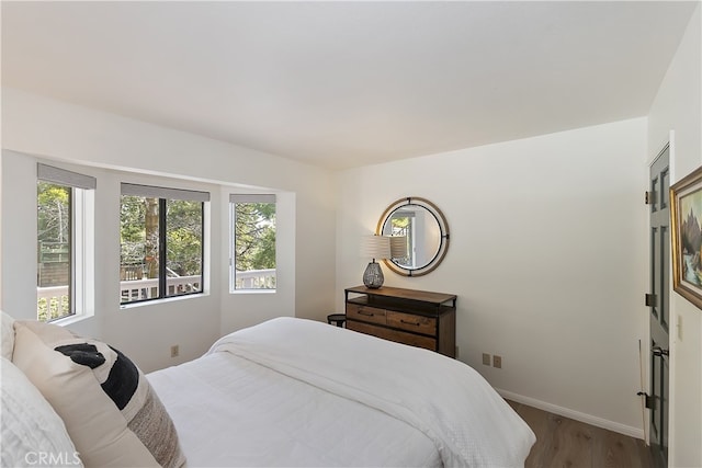 bedroom featuring baseboards and wood finished floors