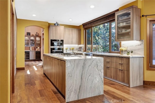 24925 Vista Verenda, Woodland Hills, CA 91367 - kitchen featuring modern cabinets, light wood finished floors, a kitchen island, light stone counters, and recessed lighting