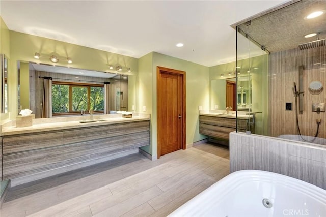 24925 Vista Verenda, Woodland Hills, CA 91367 - bathroom with a tub with jets, wood finished floors, a shower stall, two vanities, and baseboards