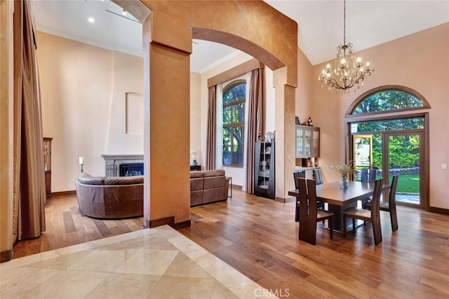 24925 Vista Verenda, Woodland Hills, CA 91367 - dining space with arched walkways, healthy amount of natural light, a towering ceiling, wood finished floors, and a chandelier