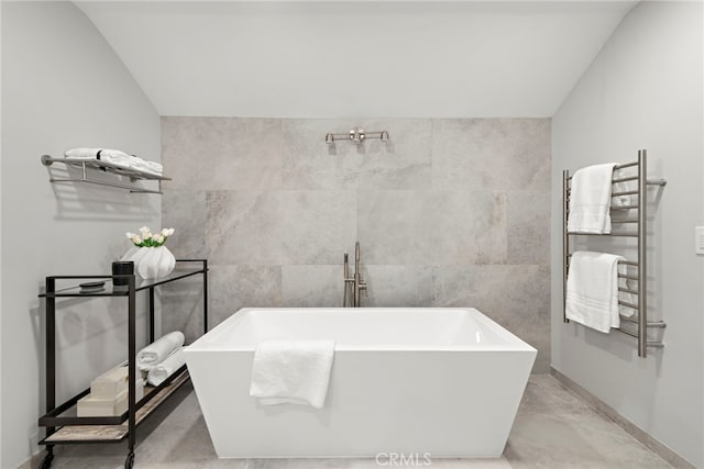15 Vista De Catalina N, Laguna Beach, CA 92651 - bathroom featuring radiator heating unit, a towel warmer, vaulted ceiling, a freestanding tub, and baseboards