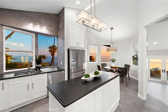 15 Vista De Catalina N, Laguna Beach, CA 92651 - kitchen featuring appliances with stainless steel finishes, a sink, dark countertops, white cabinetry, and decorative light fixtures