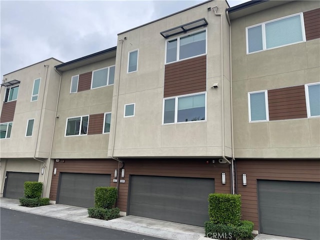 exterior space with a garage and stucco siding
