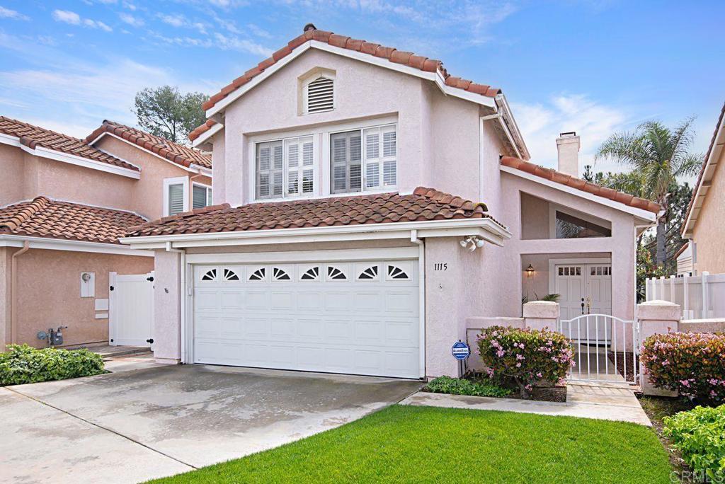 mediterranean / spanish-style house featuring a tiled roof, a gate, driveway, and fence