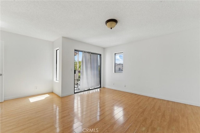 8028 Harrison St, Paramount, CA 90723 - unfurnished room with a textured ceiling, light wood-type flooring, and baseboards