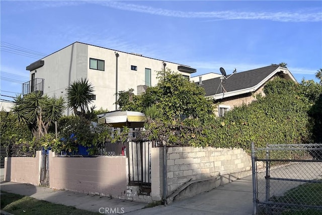 exterior space with a fenced front yard, stucco siding, and a gate