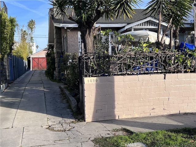 view of gate featuring an outdoor structure and fence