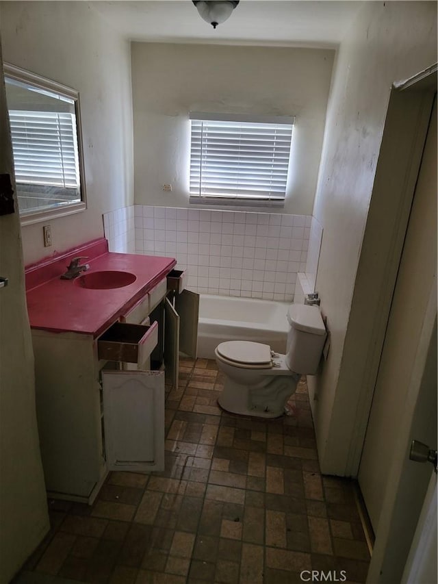 full bathroom with a washtub, brick floor, vanity, tile walls, and toilet