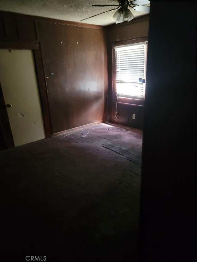 spare room with carpet floors, a textured ceiling, and a ceiling fan