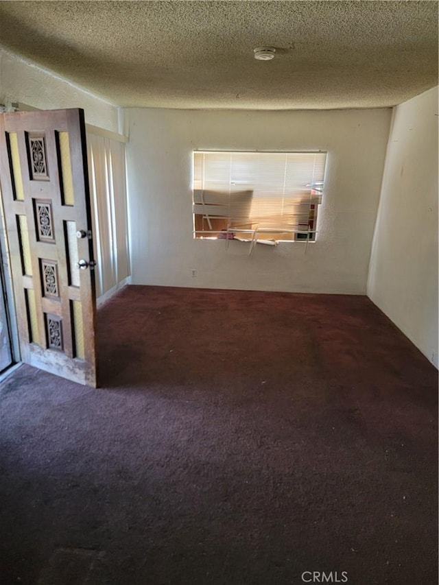 spare room featuring carpet floors and a textured ceiling