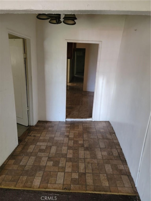unfurnished room featuring brick floor