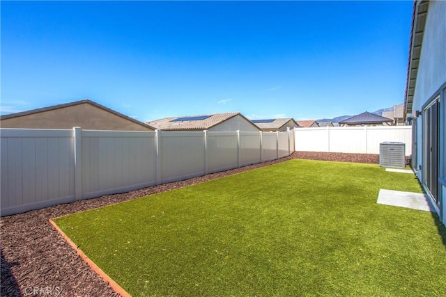 view of yard featuring central AC unit and a fenced backyard