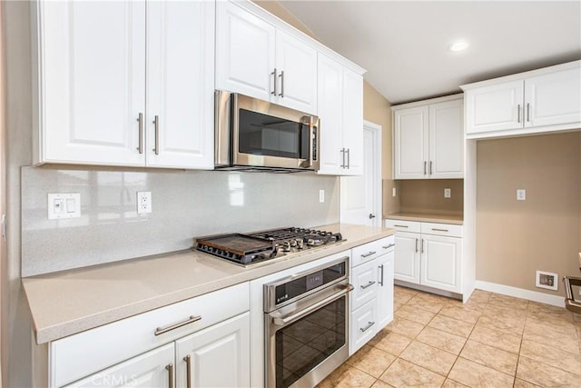 kitchen with stainless steel appliances, tasteful backsplash, white cabinetry, and light countertops