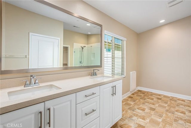 1567 Park Haven Dr, Beaumont, CA 92223 - full bathroom featuring baseboards, double vanity, a shower stall, stone finish flooring, and recessed lighting