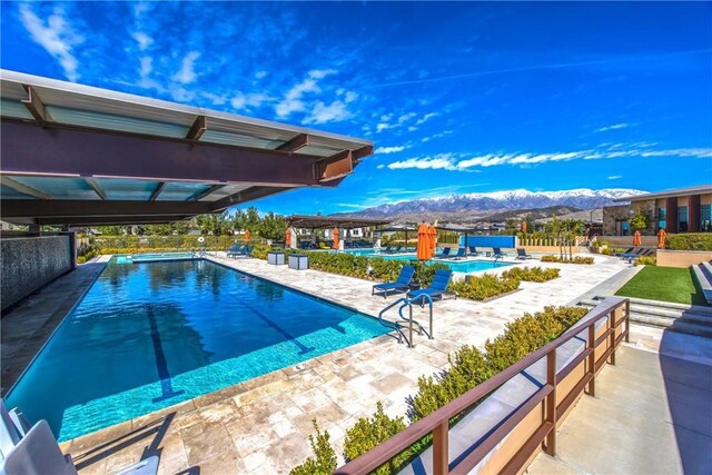 pool featuring a mountain view and a patio area